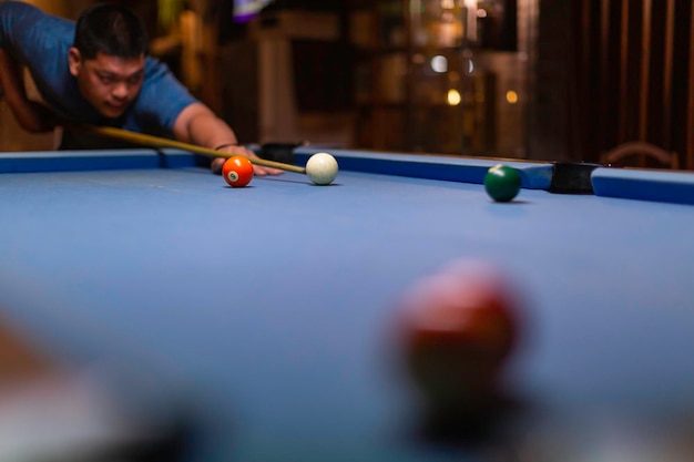 Male ball play snooker billiard player with cue aiming