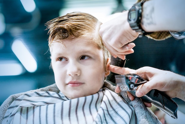 Photo a male barber's hand trimming boys hair