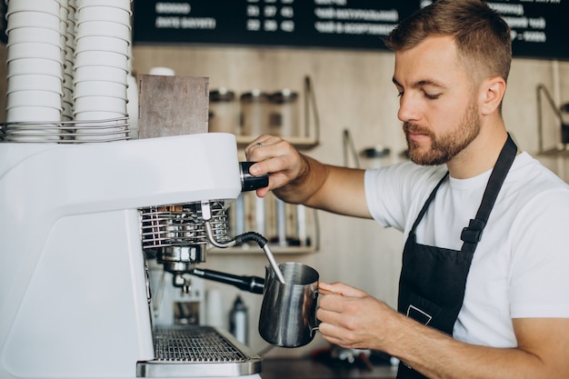 喫茶店でコーヒーを準備する男性のバリスタ