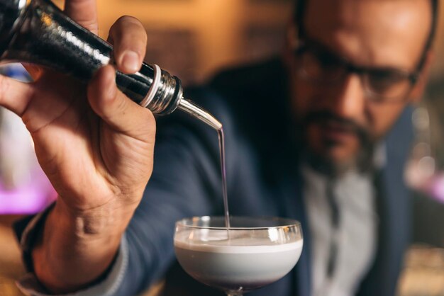 Foto barista che prepara un cocktail al bancone del bar