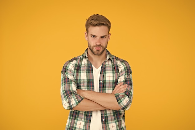 Male beauty standards masculine outfits and look stylish male in fashionable clothing handsome man in checkered shirt and jeans confident student yellow background casual fashion for men
