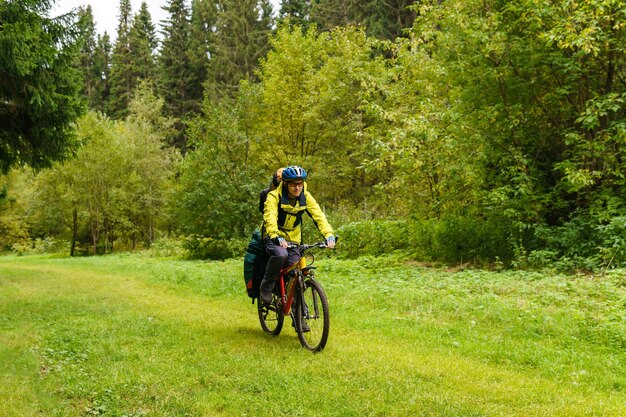 男性の自転車観光客が秋の森を駆け抜ける