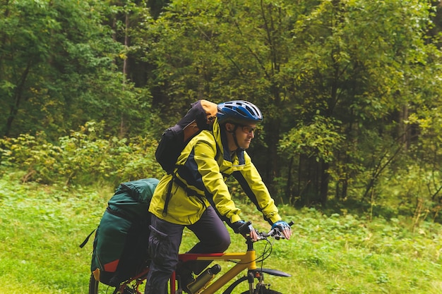 男性の自転車観光客が秋の森を駆け抜ける