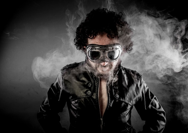 Photo male biker with sunglasses era dressed leather jacket, huge smoke over dark background