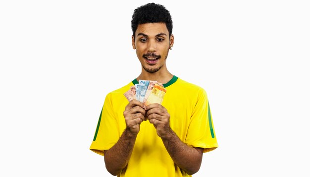 Male black athlete with uniform holding brazilian money. Sportsman isolated 