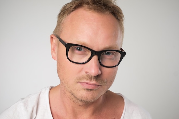 Male blogger wears spectacles and white tshirt looks confidently