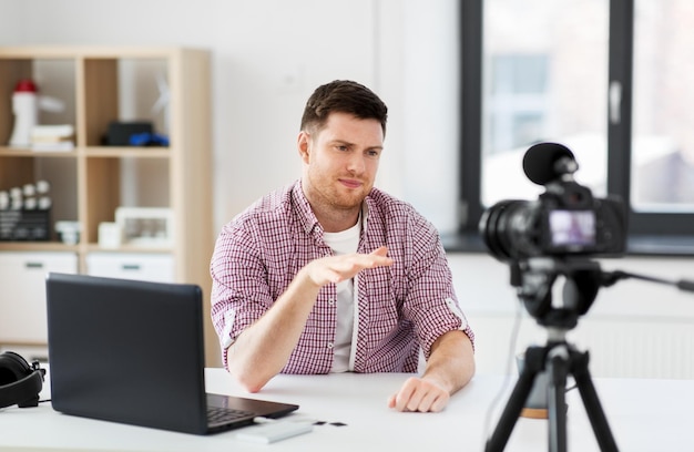 male blogger with camera videoblogging at home