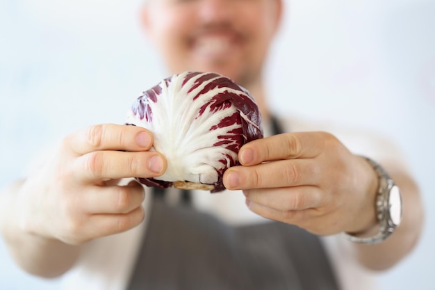 キッチンの健康的な菜食主義の食糧ブログの有機性および紫色の野菜との男性ブロガー