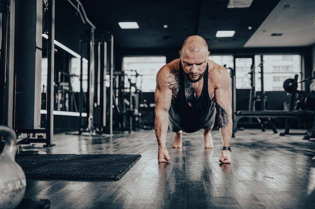 Male bodybuilder performing push  ups on his fists