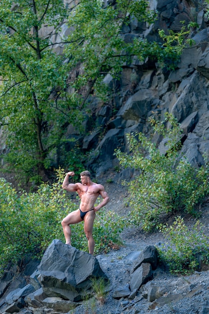 Male bodybuilder on the rok in nature fitness and healthy