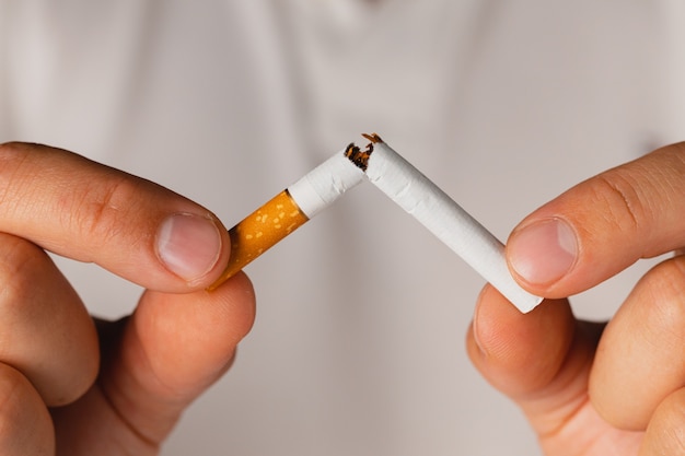 Male breaking cigarette in hands quitting bad habit