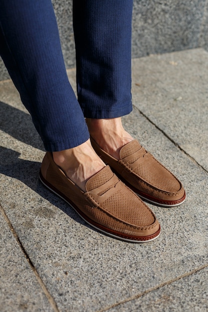 Male brown shoes made of genuine leather close-up on male feet