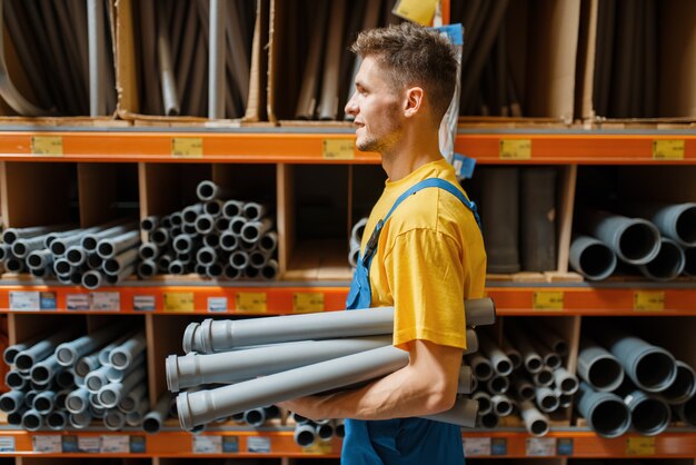 Male builder choosing piping in hardware store