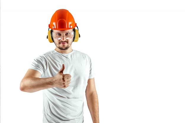 Male builder in orange helmet shows thumb up isolated on white background