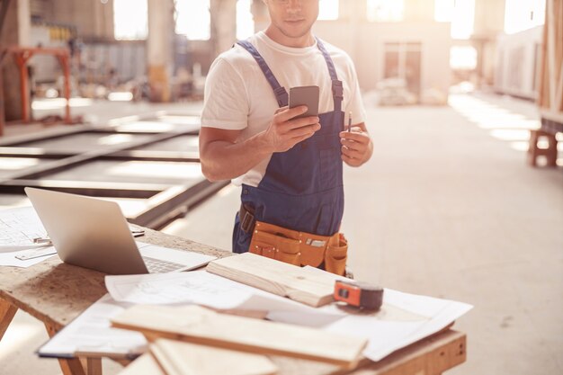 Male builder using mobile phone at construction site