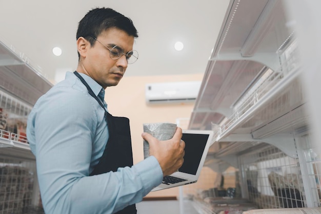 Male business owner checking product sale on shelf