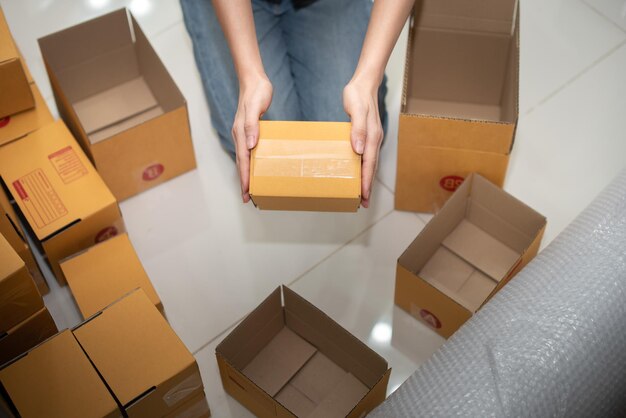 Male business owner working packing the order for shipping to
customer working with laptop