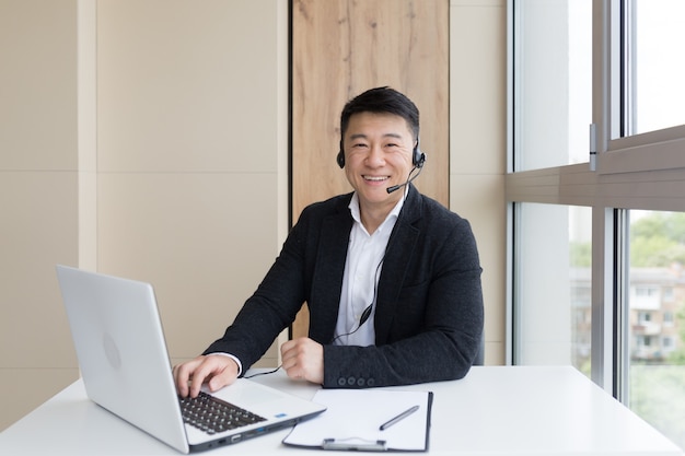 Male businessman conducts online training using a headset and laptop