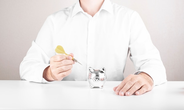 Photo male businessman hits the target with darts. dice aspiration concept with money box