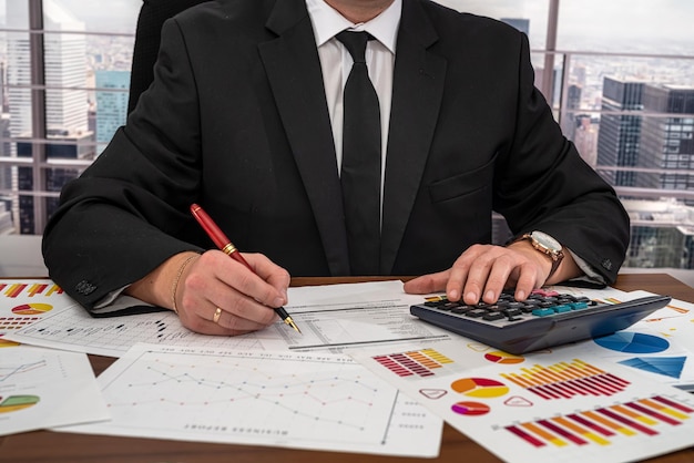 Мужчина-бизнесмен в суперкостюме и галстуке делает платежи бизнесу за столом Концепция бизнеса и денег