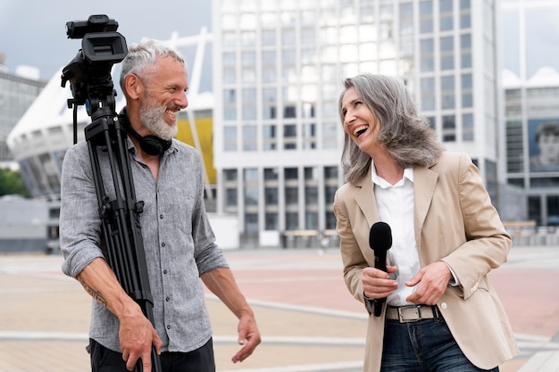 Cameraman maschio che parla con una giornalista donna