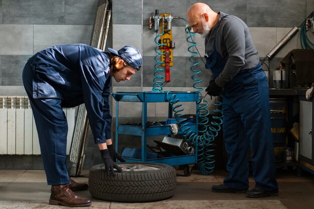 Foto meccanico di automobile maschio che lavora nell'officina di riparazione dell'automobile