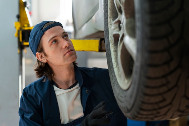 Foto meccanico di automobile maschio che lavora nell'officina di riparazione dell'automobile