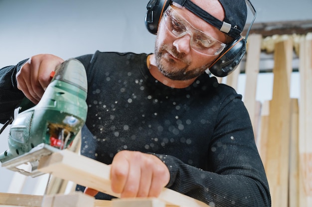 Photo a male carpenter while working manufacture of wood products