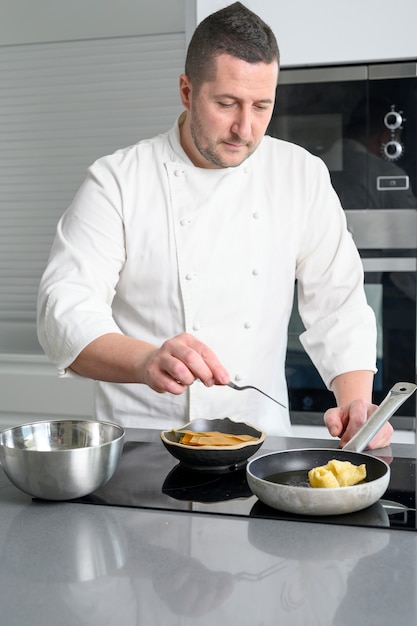 Male chef cooking on frying pan.