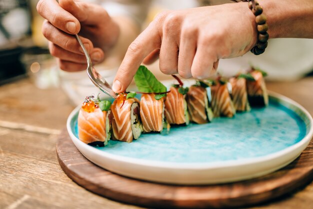 Male chef cooking sushi rolls, japanese food