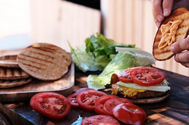 Foto mani maschii del cuoco unico che preparano gli hamburger