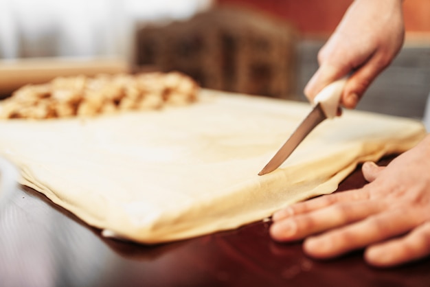 Male chef prepares apple strudel