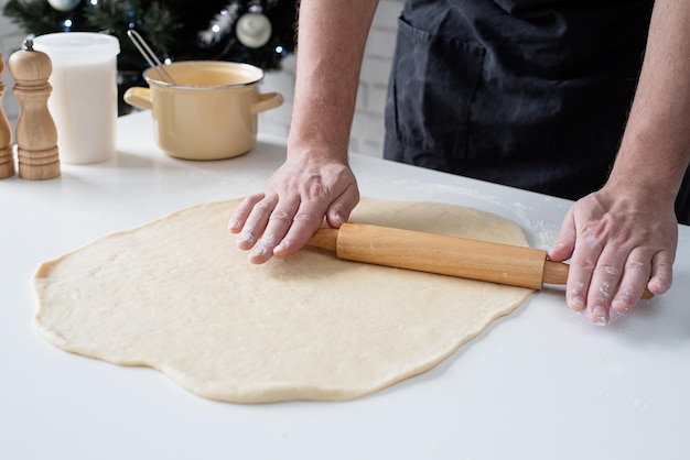 Male chef working with dough cooking cinnamon rolls