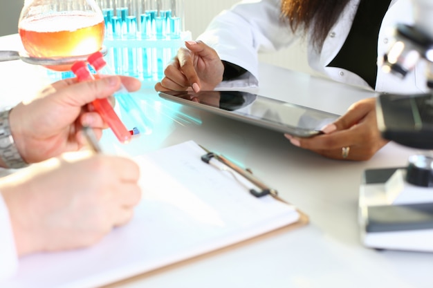 male chemist holds test tube of glass