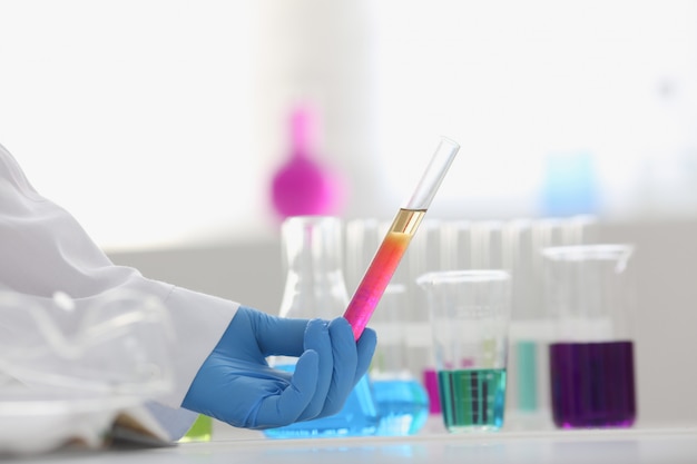 A male chemist holds test tube of glass