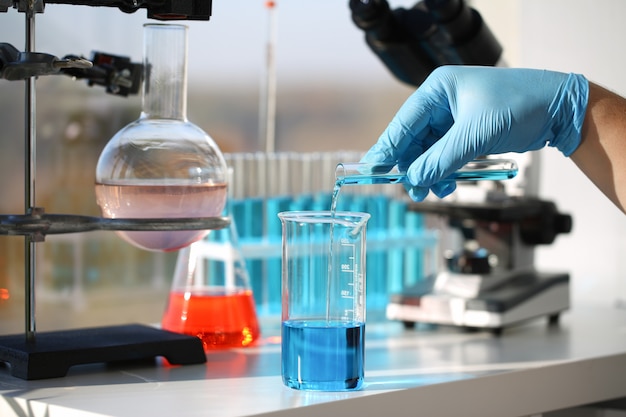 A male chemist holds test tube of glass