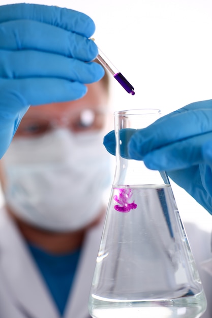 A male chemist holds test tube of glass