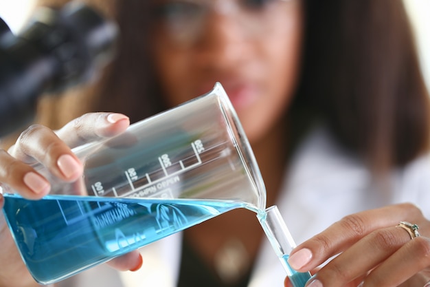 A male chemist holds test tube of glass