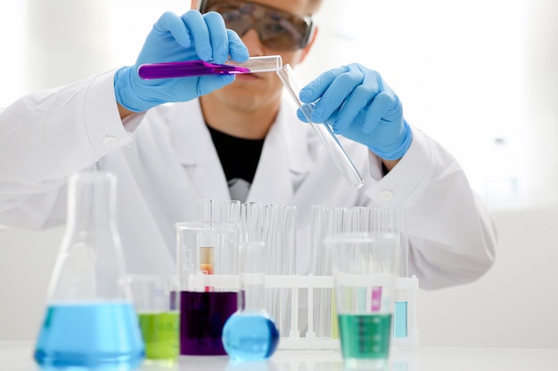 A male chemist holds test tube of glass in