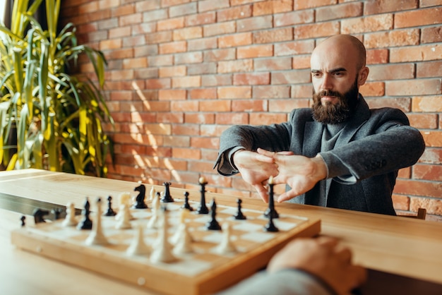 Male chess players on competition, board with figures.