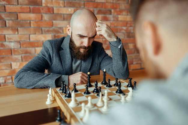 Male chess players playing, thinking process.