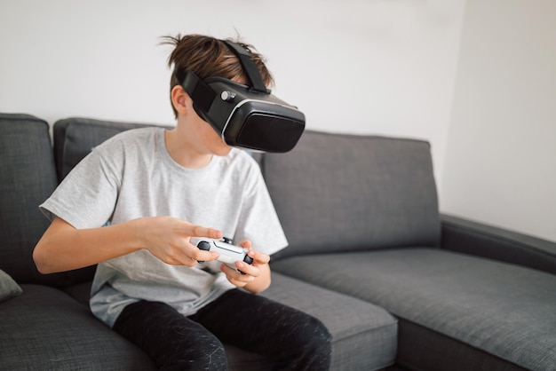 Мальчик с VR-гарнитурой, держащий геймпад, играющий в симуляторные игры