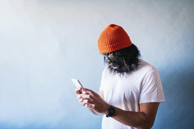 Male in a chimpanzee mask using his mobile phone