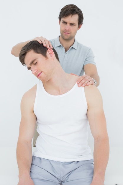 Male chiropractor doing neck adjustment