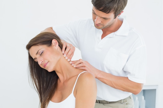 Male chiropractor massaging a young womans neck