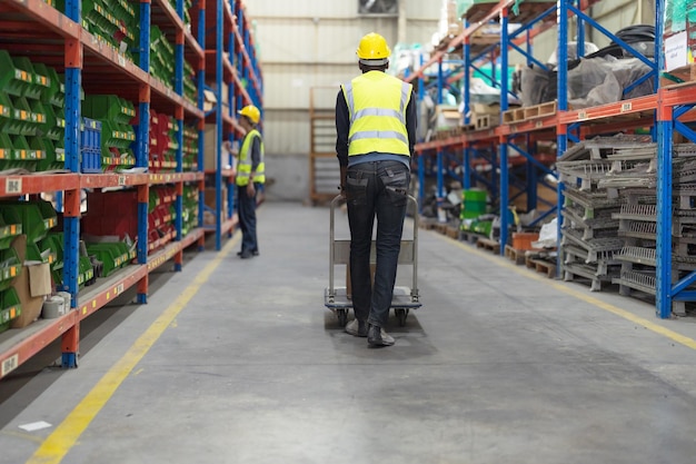 Photo male clerk pushing a cart or picking cart