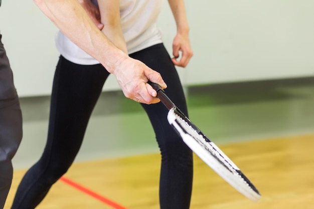 Male coach teaches a child how to hold a tennis racket\
horizontal photo