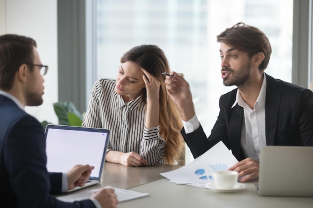 Male colleagues argue having dispute at company briefing woman\
worker stay calm and peaceful managing stress distracted form\
conflict managers or partners disagree on terms at meeting