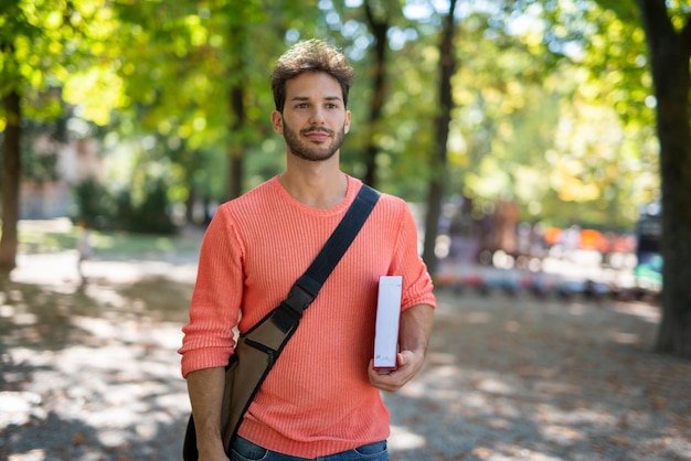 Photo male college student walking in a park