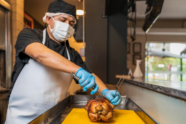 Photo male cook preparing a roasted chicken for client in the restaurant